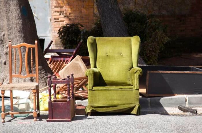 A green chair is sitting in the middle of a pile of chairs.