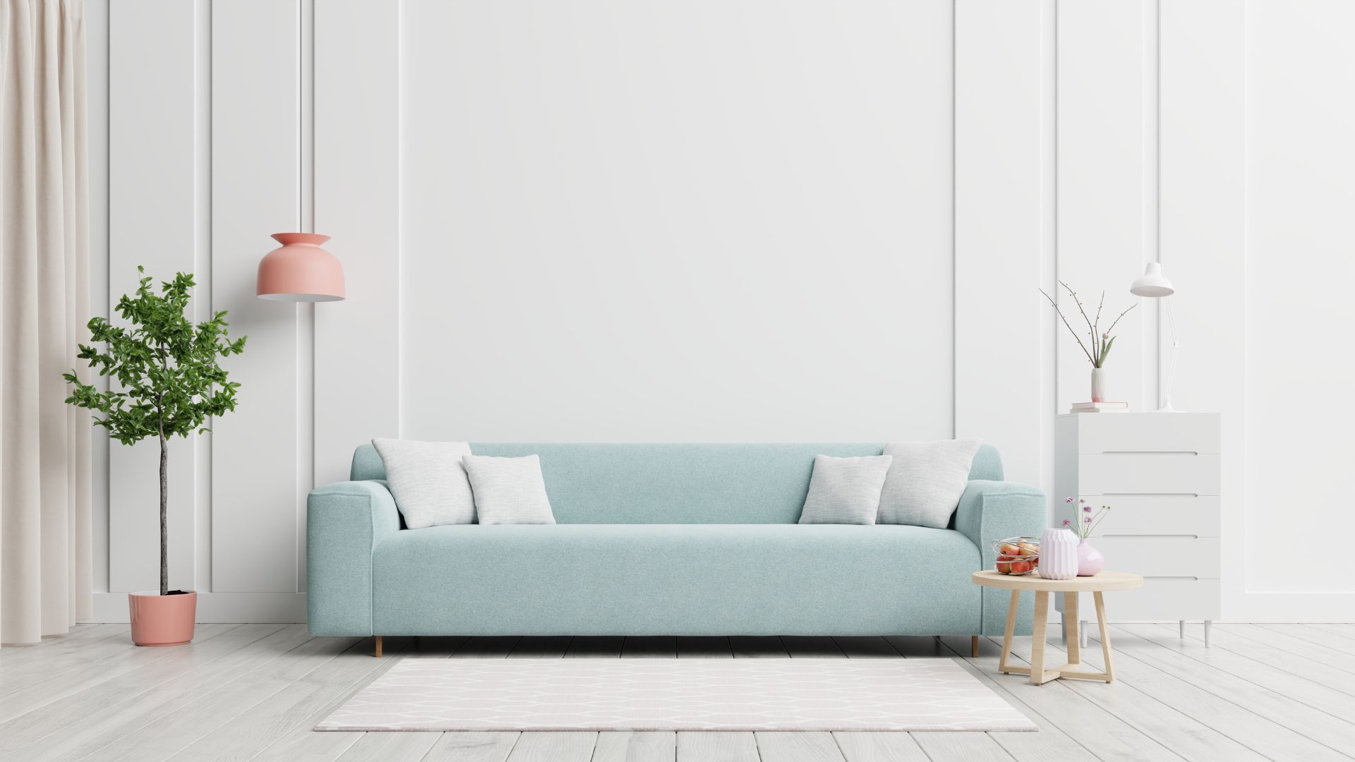 A living room with a blue couch and a white wall.