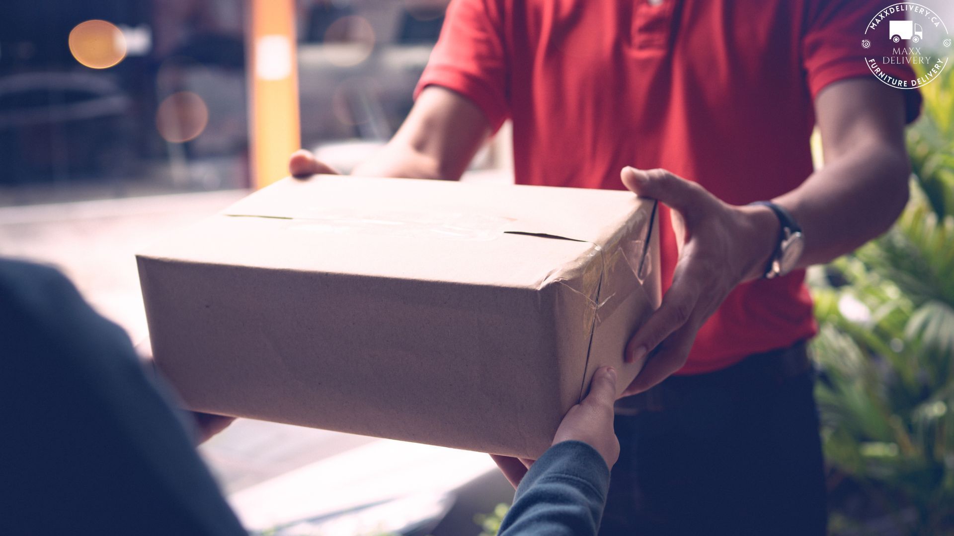 A man in a red shirt is handing a box to a woman