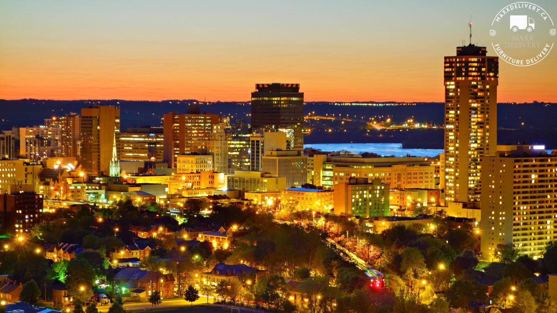 An aerial view of a city at night with a sunset in the background