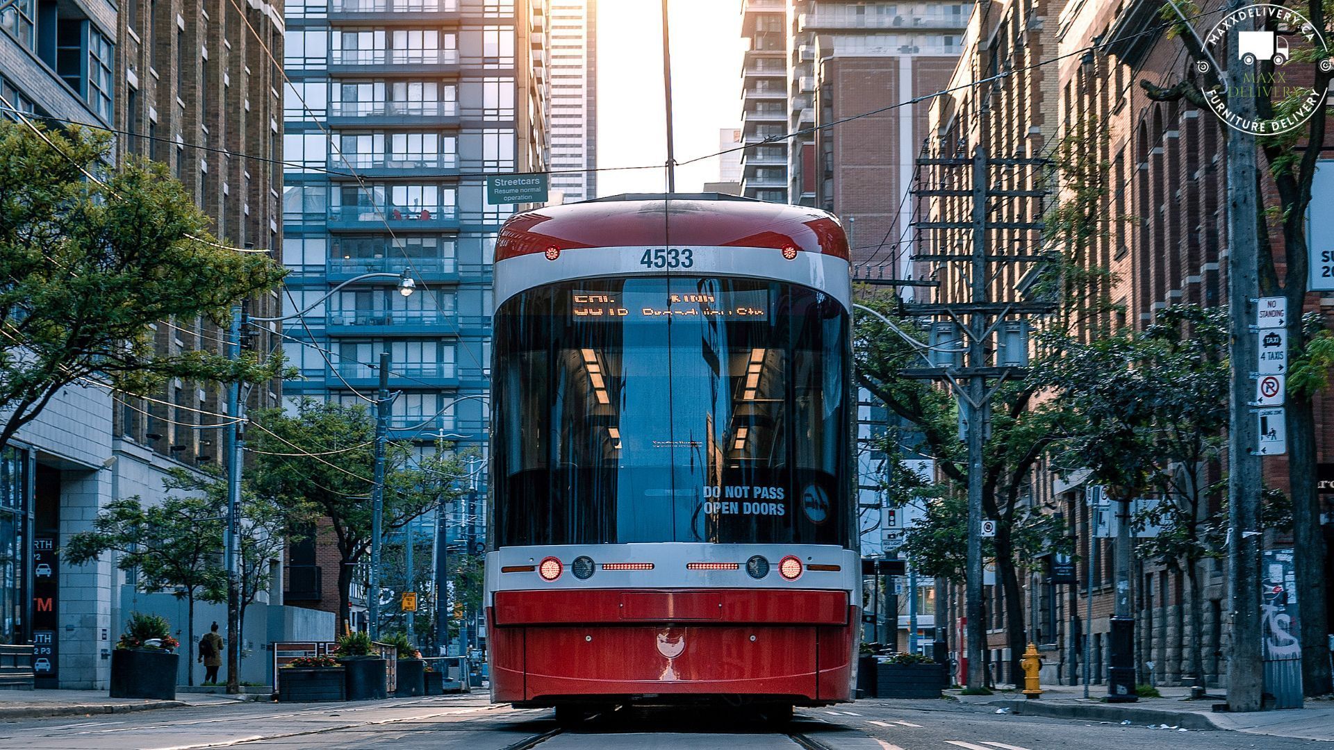 A red trolley is driving down a city street