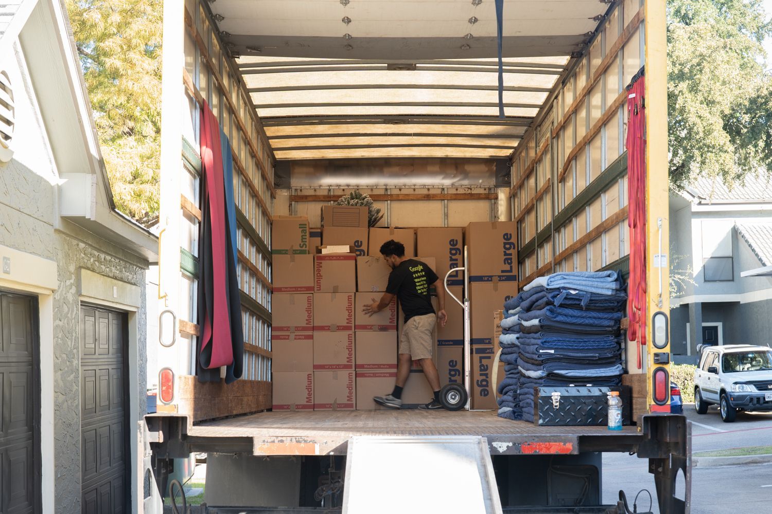 A man is loading boxes into a moving truck that says kraft