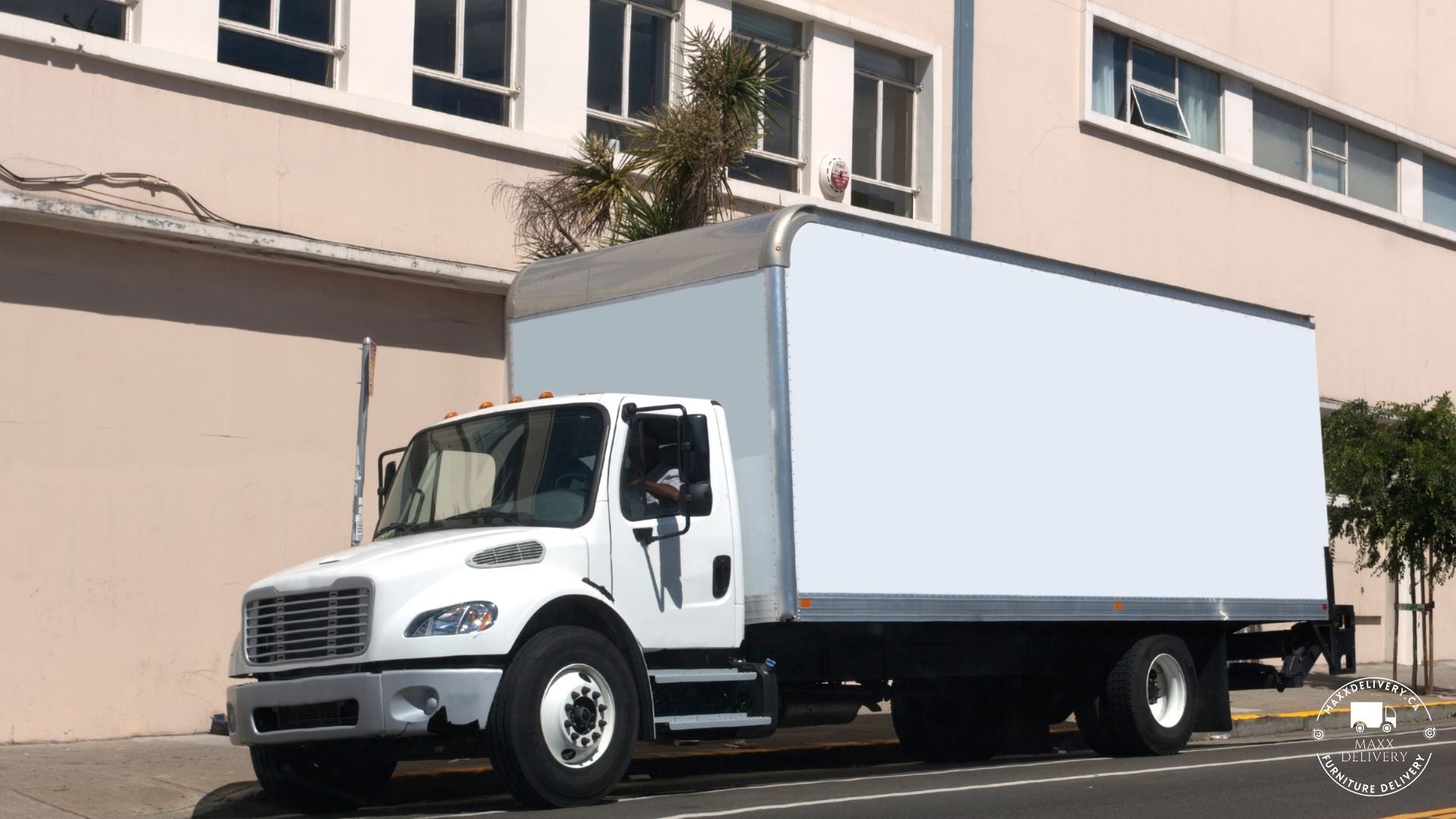 A white truck is parked in front of a building