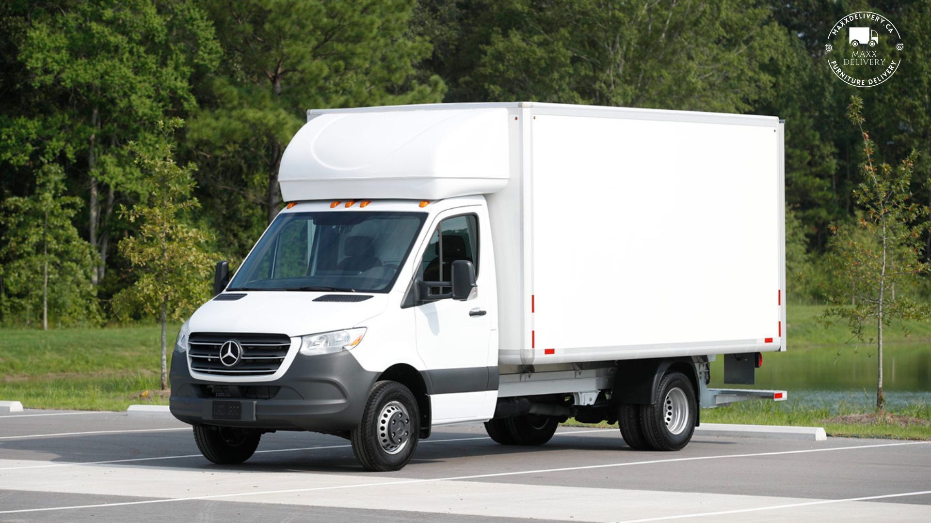 A white box truck is parked in a parking lot