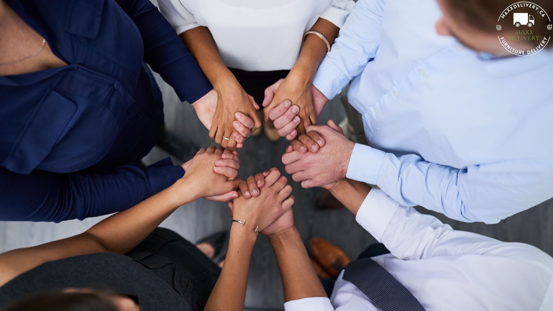 A group of people are putting their hands together in a circle