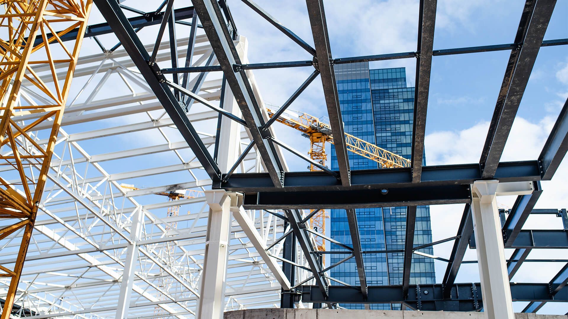 A building under construction with a skyscraper in the background