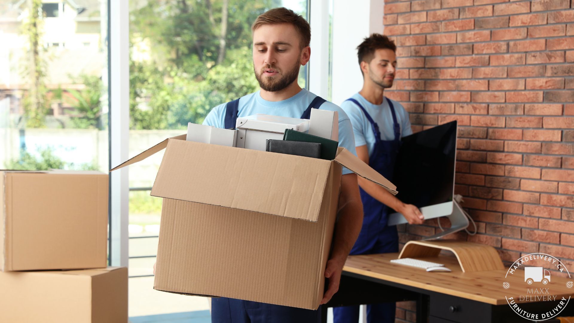 A man is carrying a cardboard box full of papers.