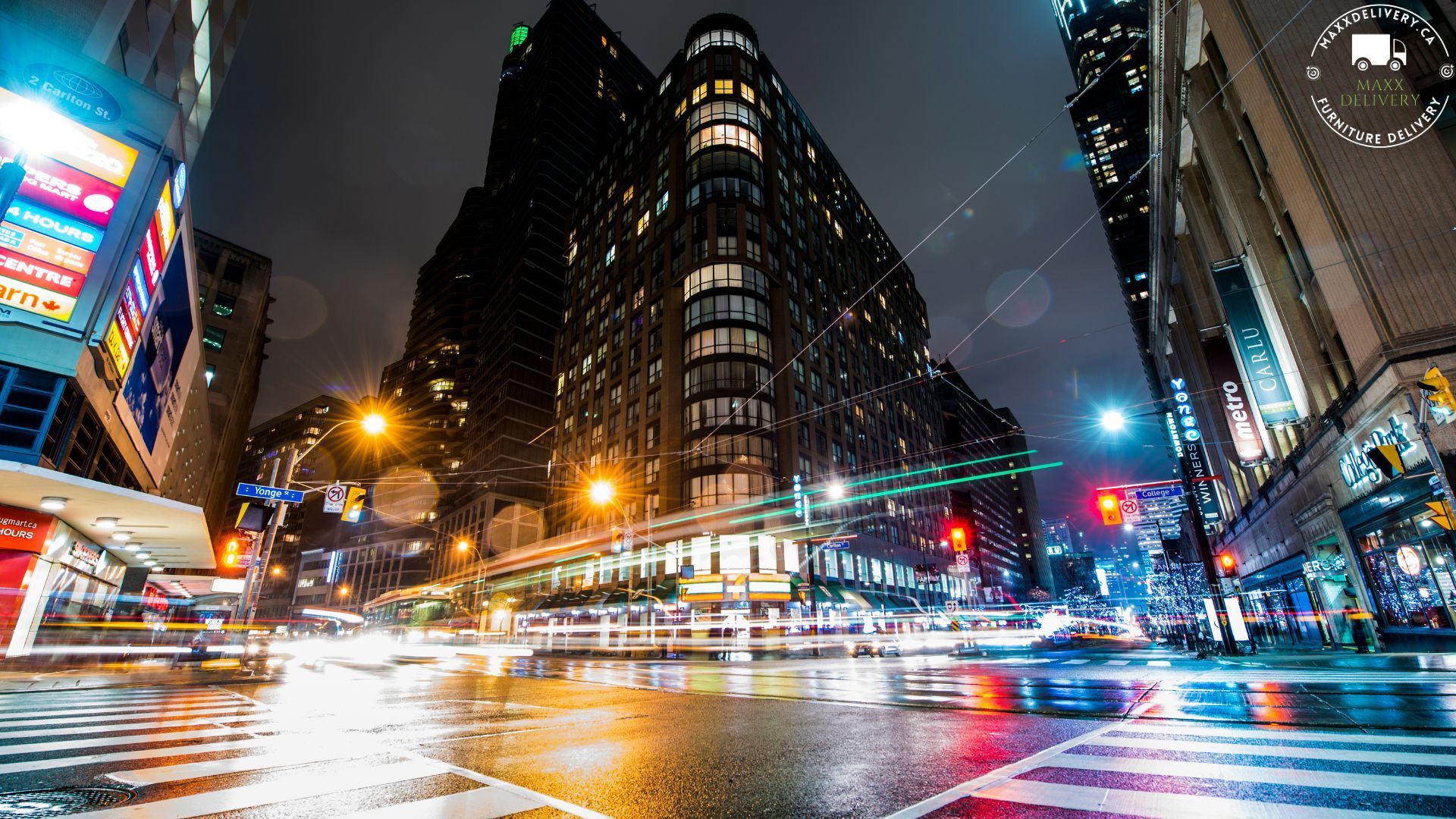 A city street at night with a clock in the background