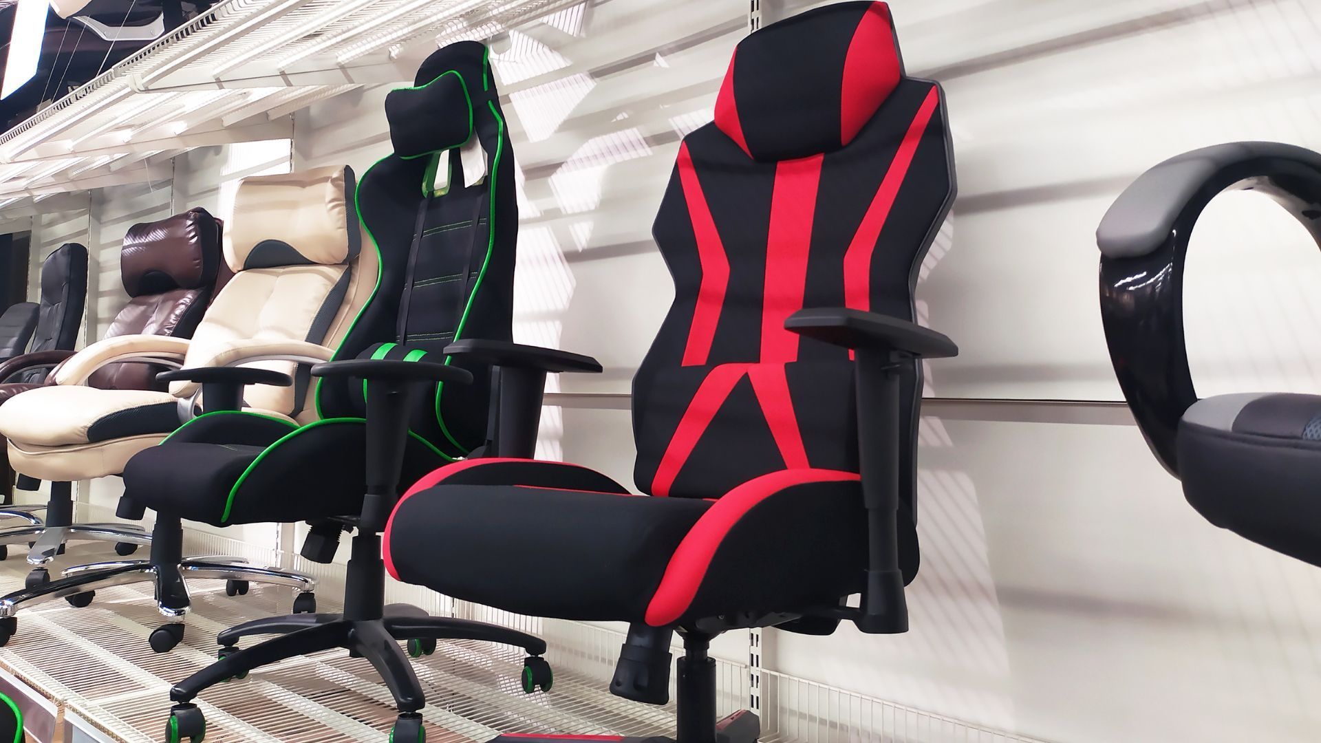 A row of gaming chairs are on display in a store