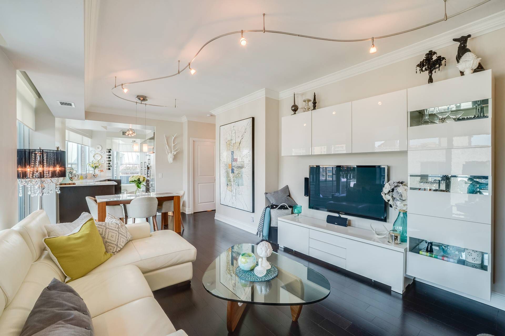 A living room with a white couch and a glass coffee table