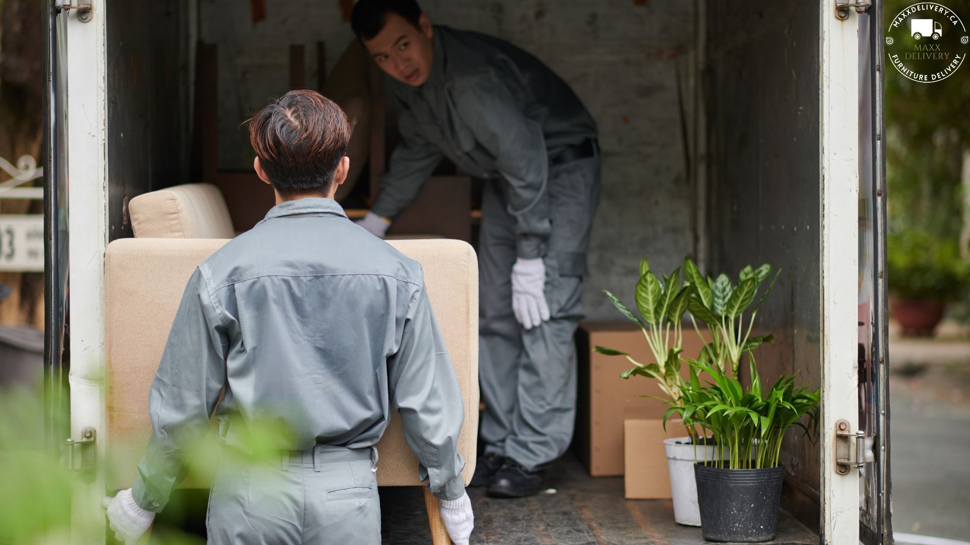 Two men are loading a couch into a truck.