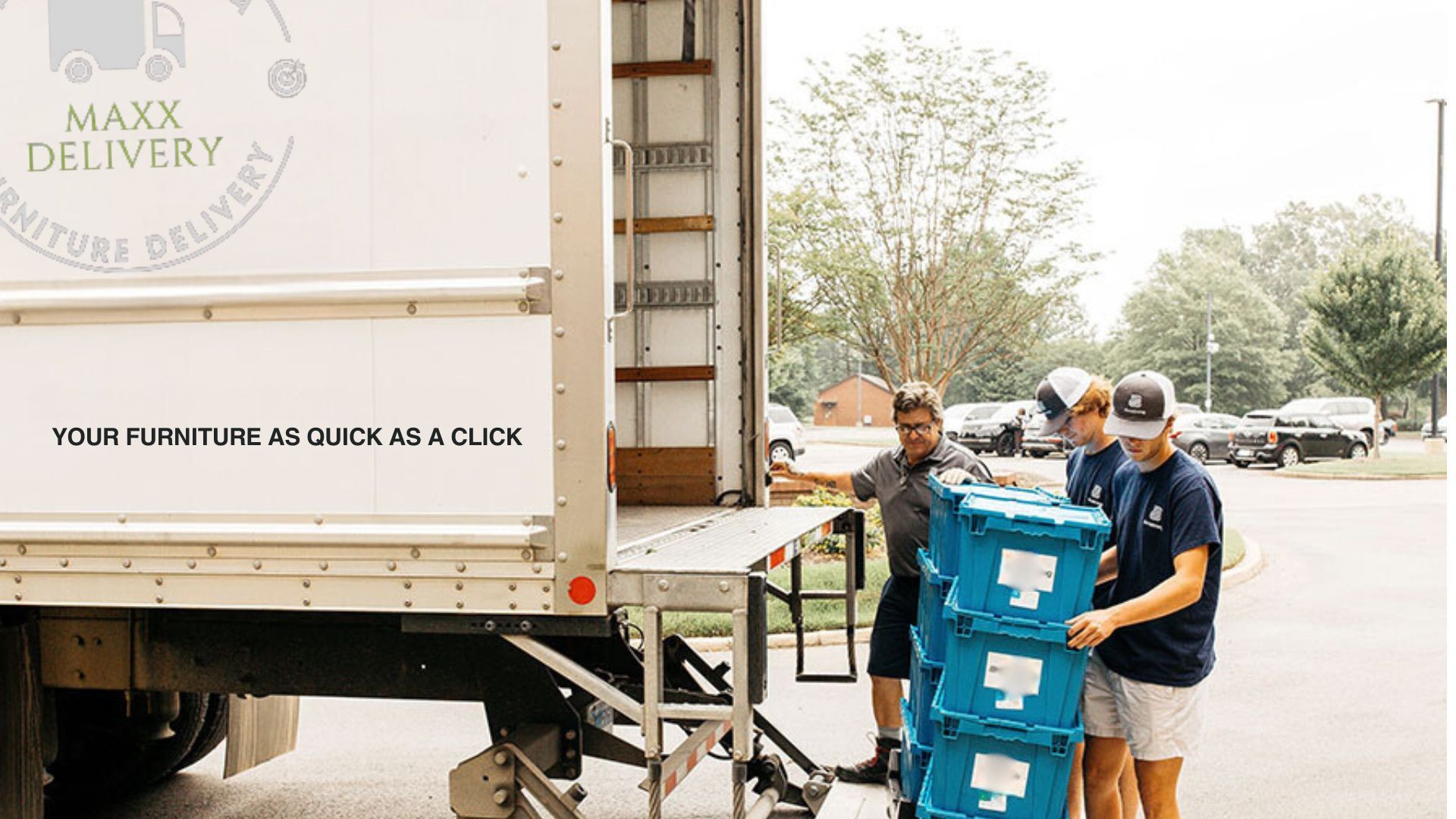 Three men are loading boxes into a max delivery truck