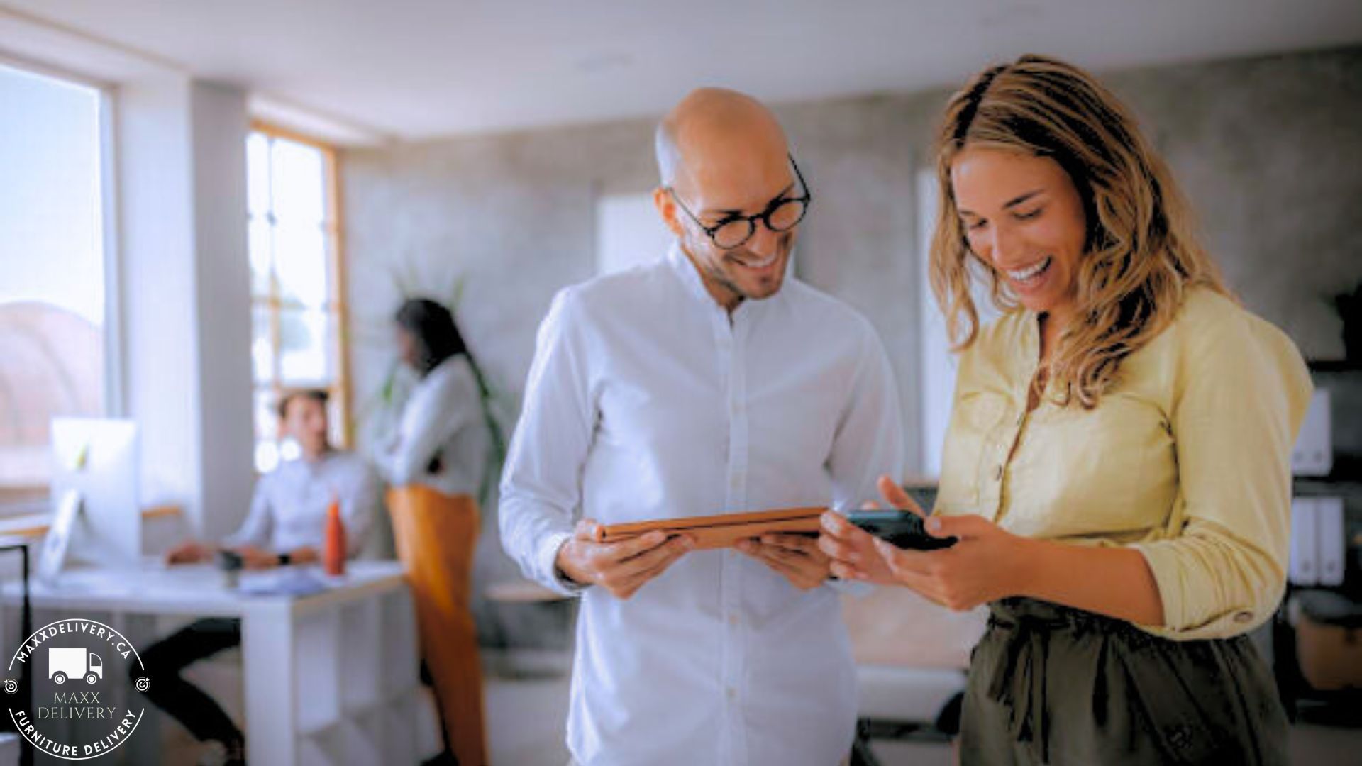 A man and a woman are looking at a tablet in an office - condo moving