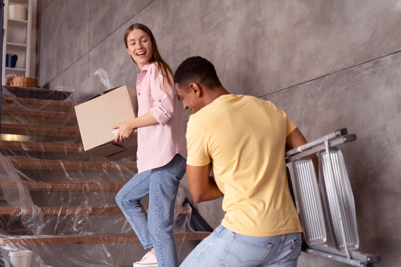 A man and a woman are moving up a set of stairs.