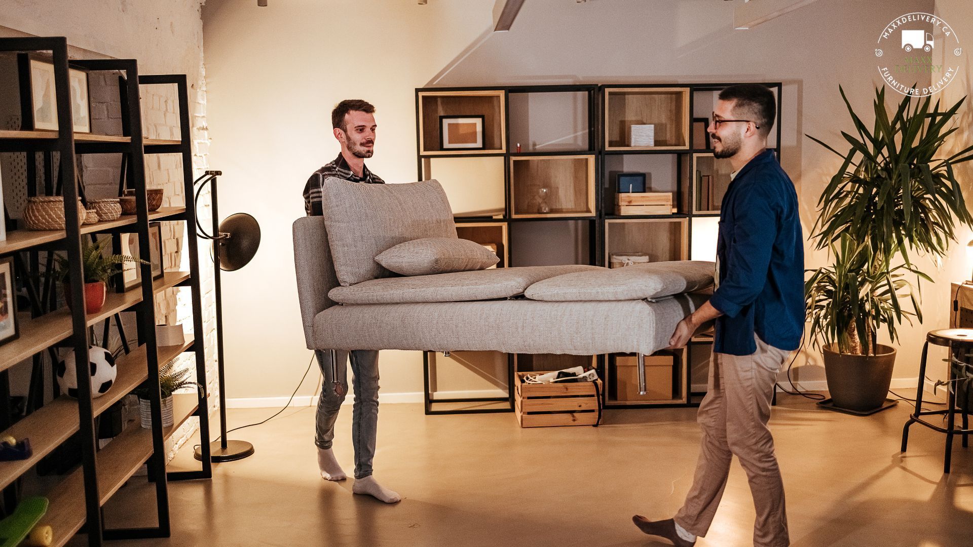 Two men are carrying a couch in a living room. - Furniture delivery