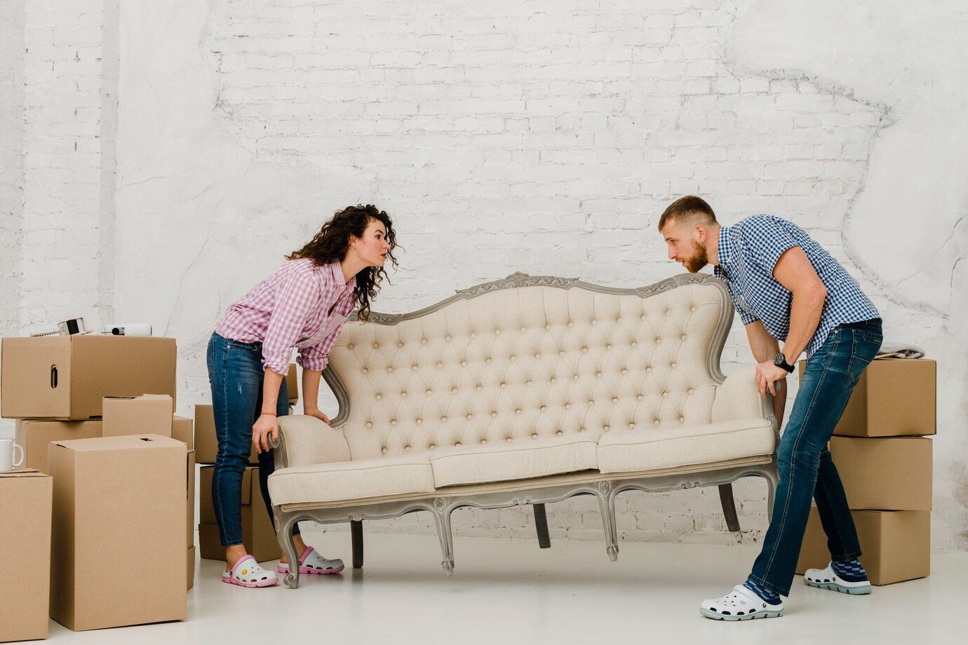 Sofa Toronto | Couple moving beige chesterfield jeans  crocs white wall furniture assembly by MaxxDelivery.ca