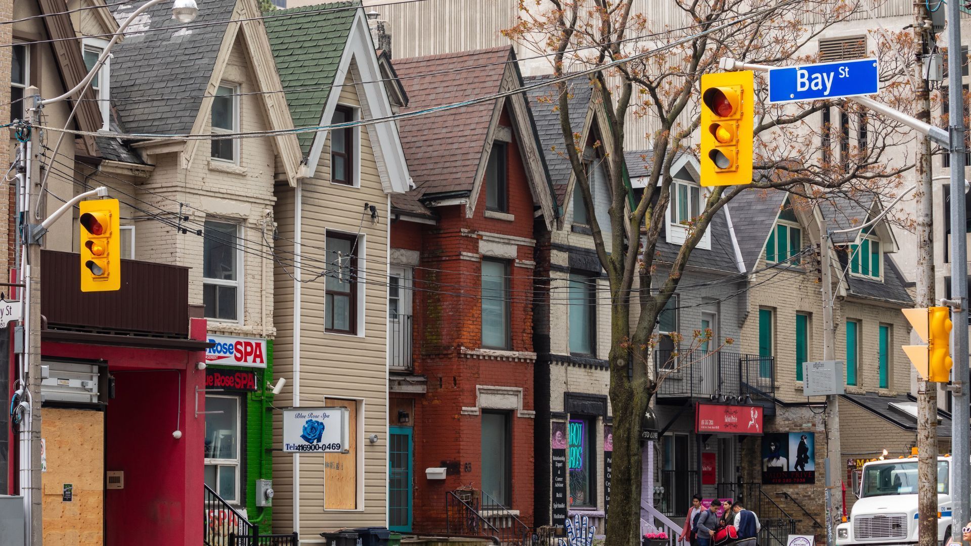 A row of houses with a blue street sign that says urg