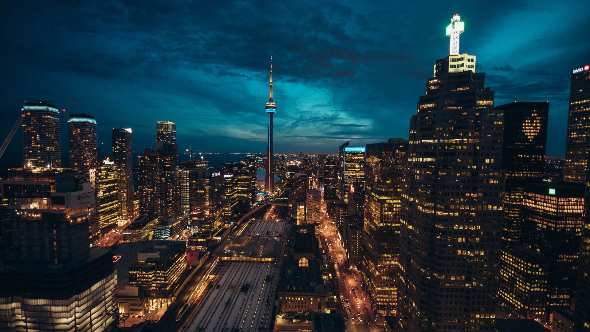 An aerial view of a city at night with a cross on top of a building