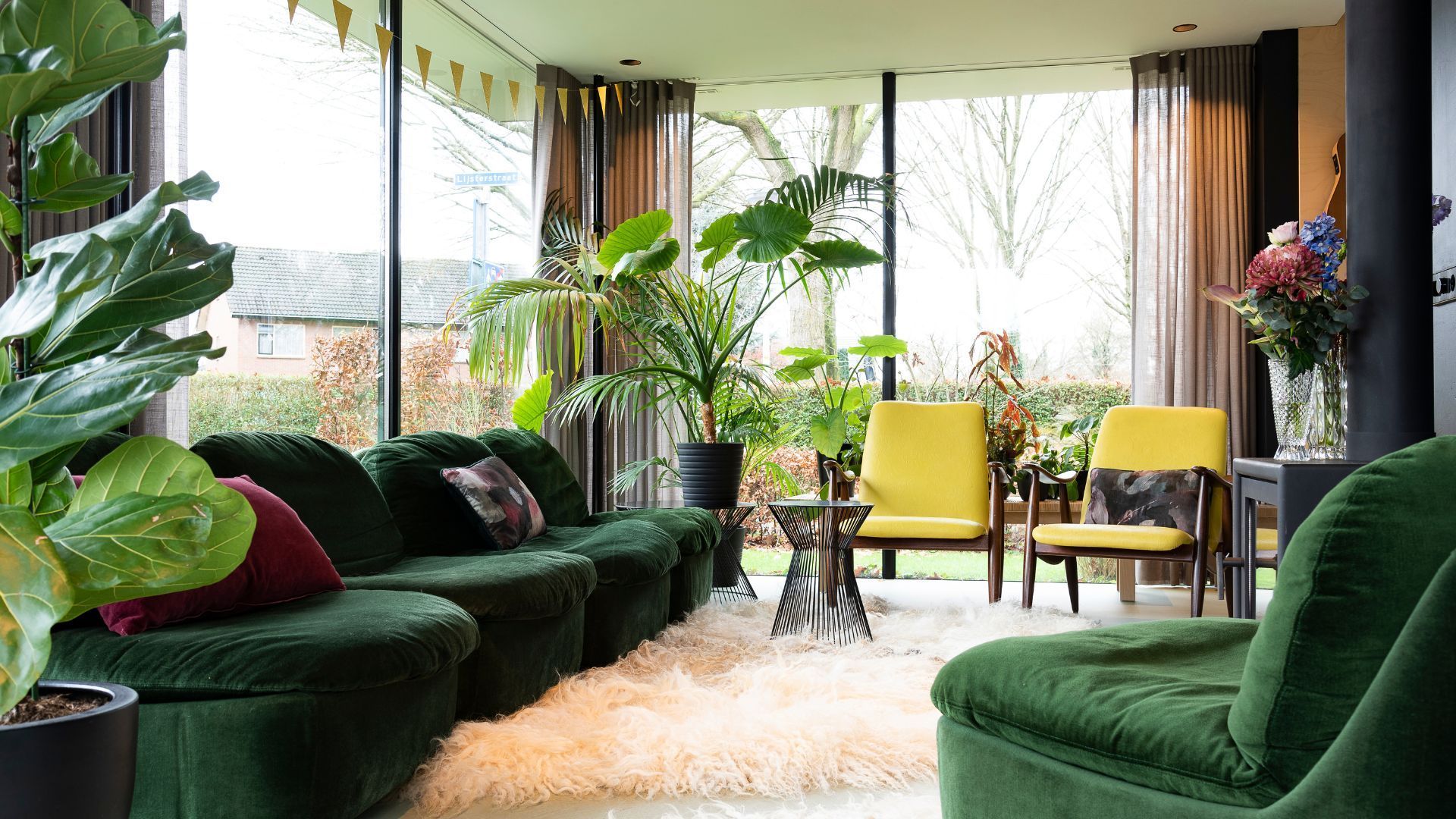 A living room with green furniture and yellow chairs