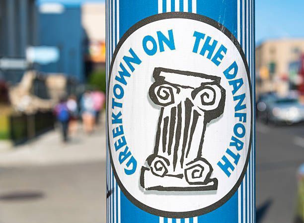 A blue and white sign that says greektown on the danforth