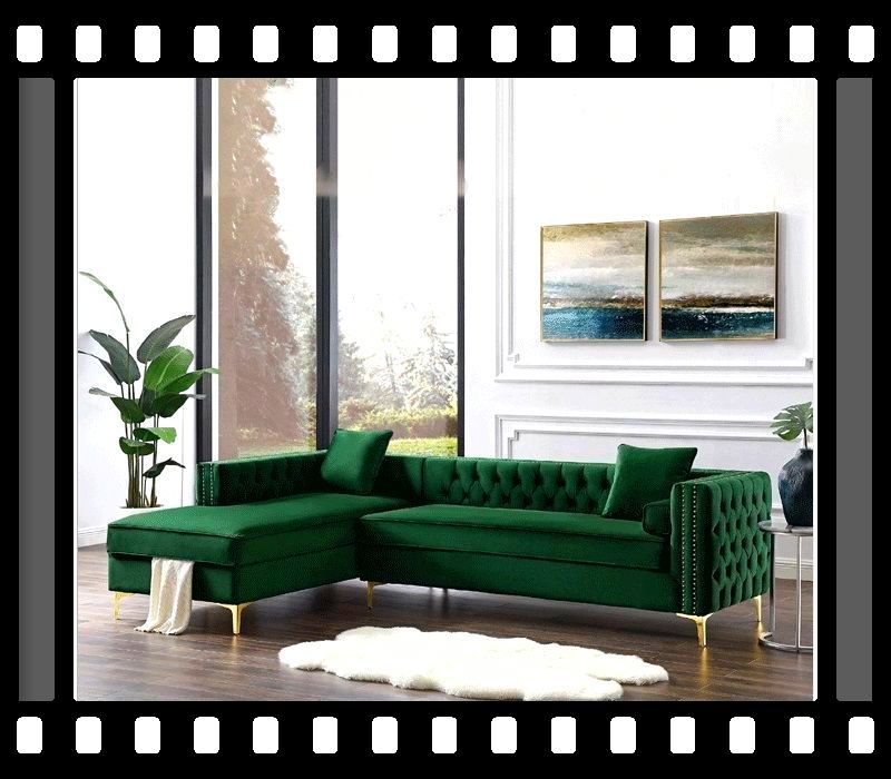 A living room with a green sectional couch and two paintings on the wall