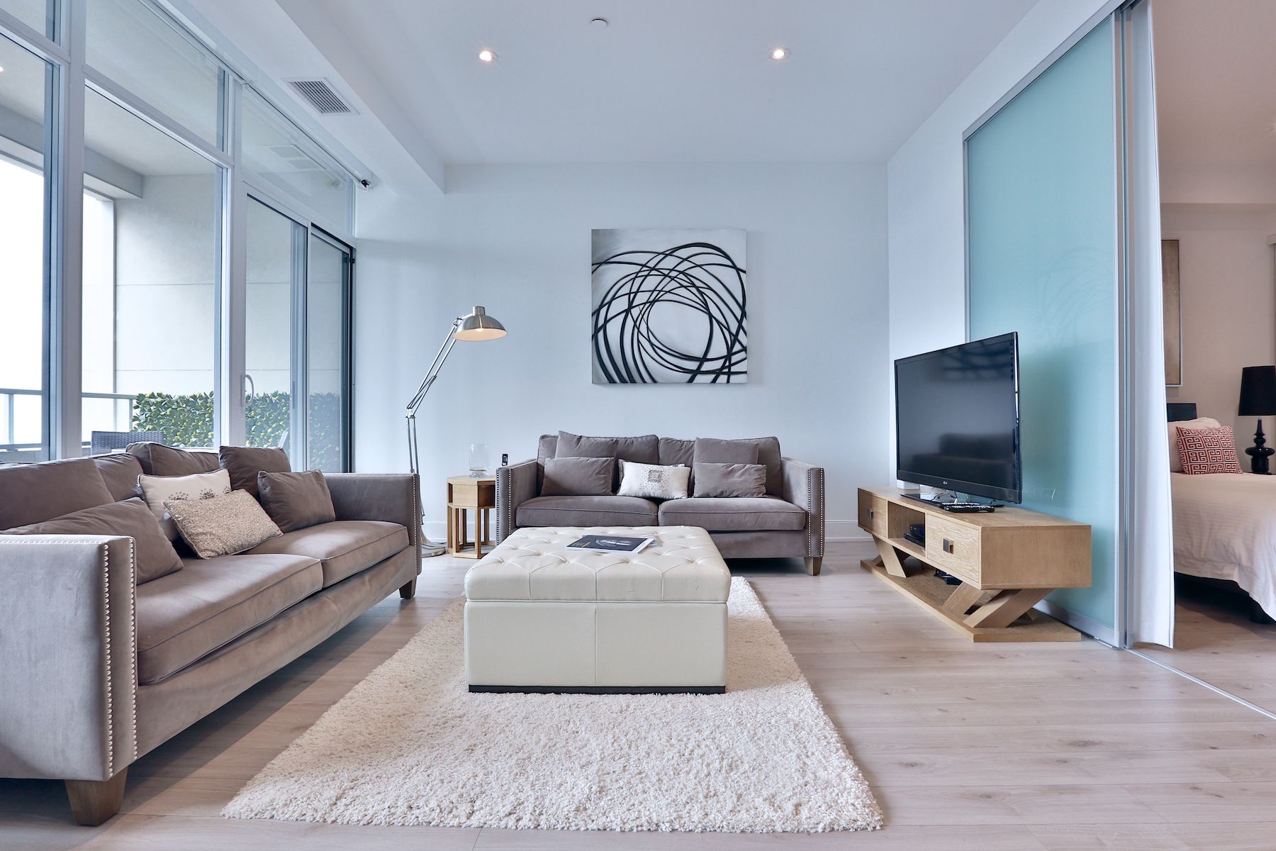 A living room with a couch ottoman and television