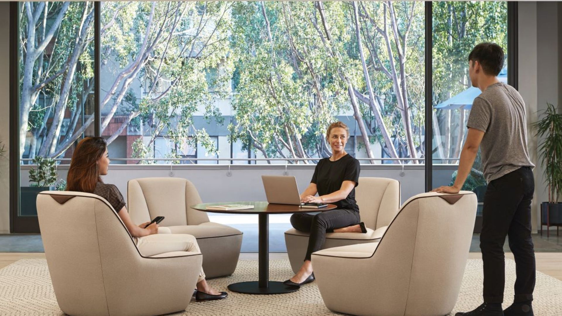 A group of people sitting around a table with a laptop - furniture movers