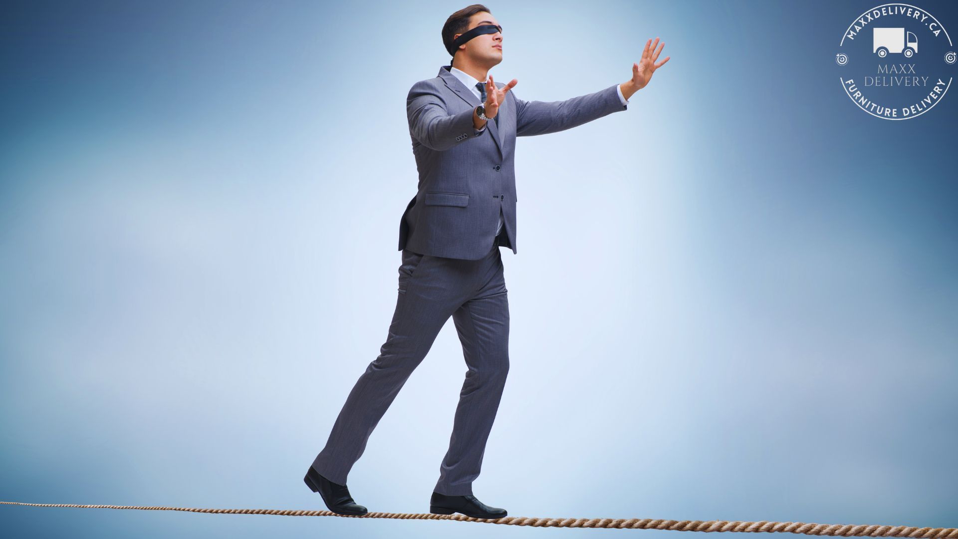 A man in a suit and blindfold is walking on a rope