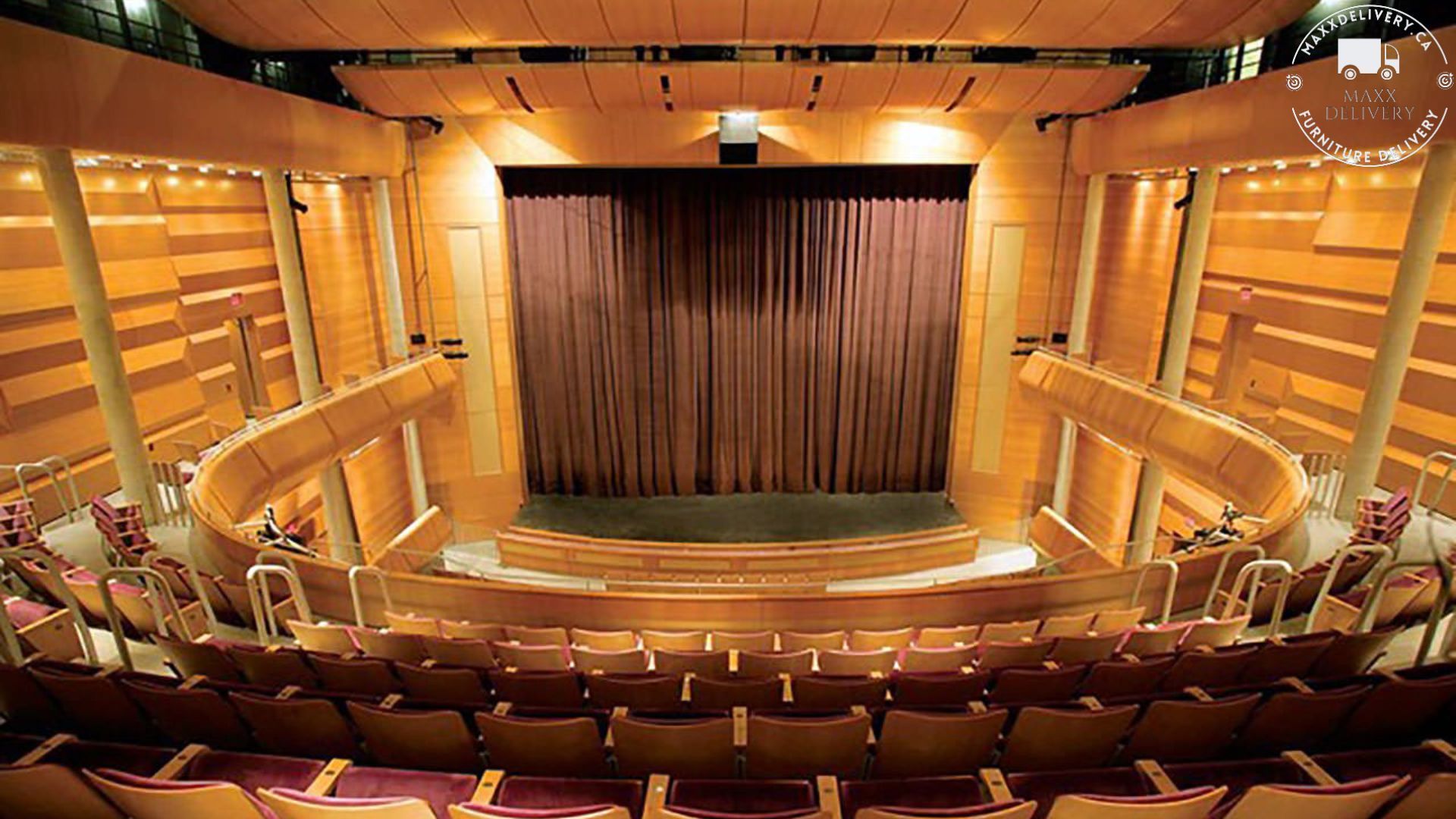 An empty auditorium with red seats and a stage