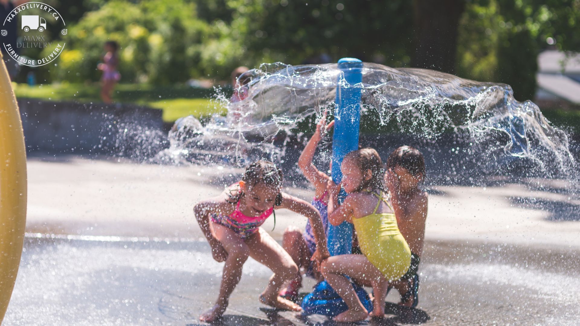 A group of children are playing in a water fountain