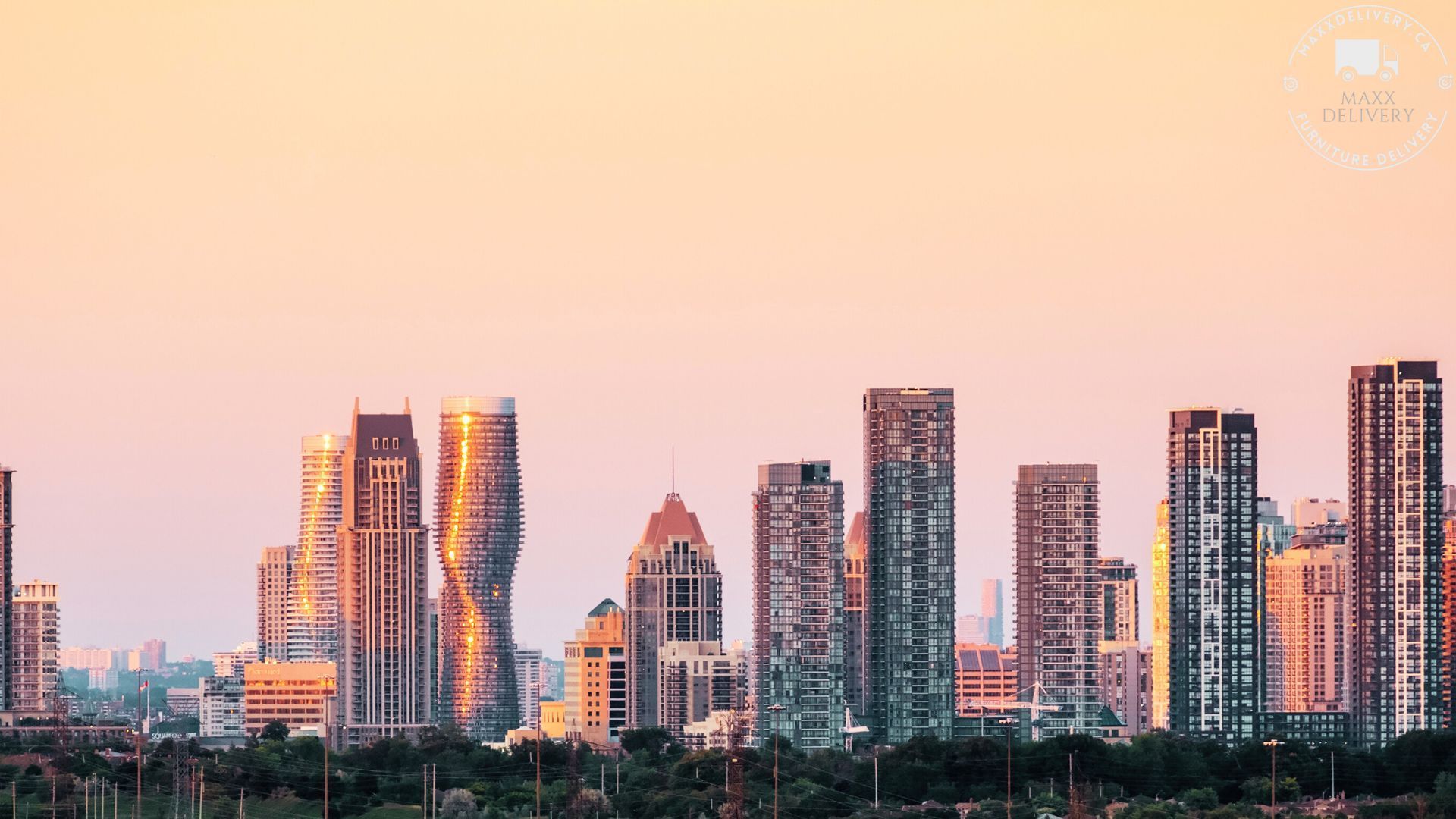 A city skyline with a pink sky in the background