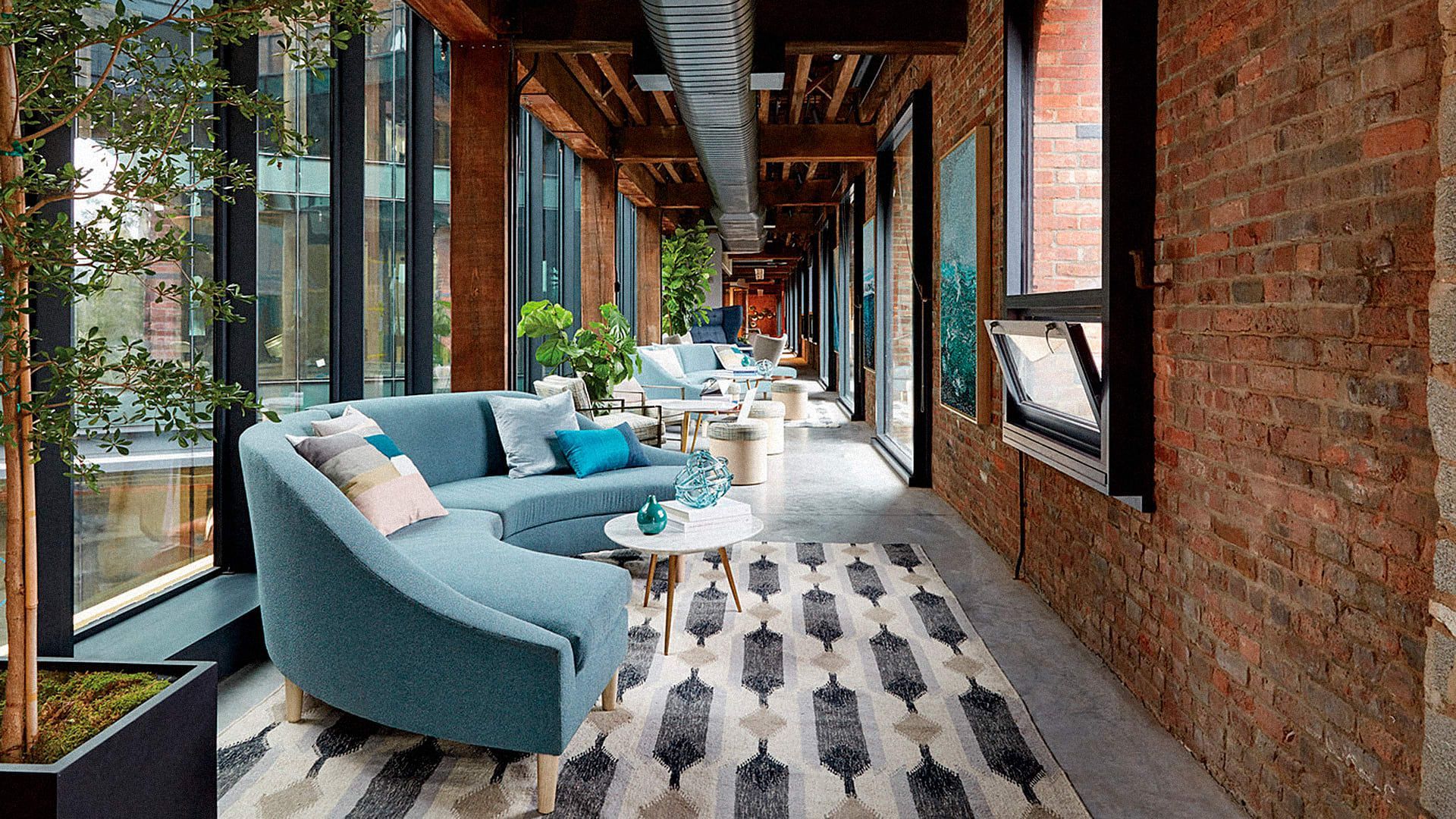 A living room with a blue couch and a rug