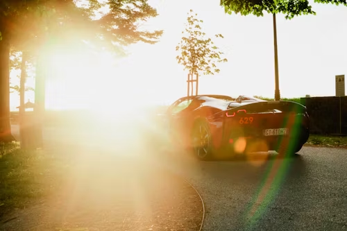 A black sports car is parked on the side of a road.