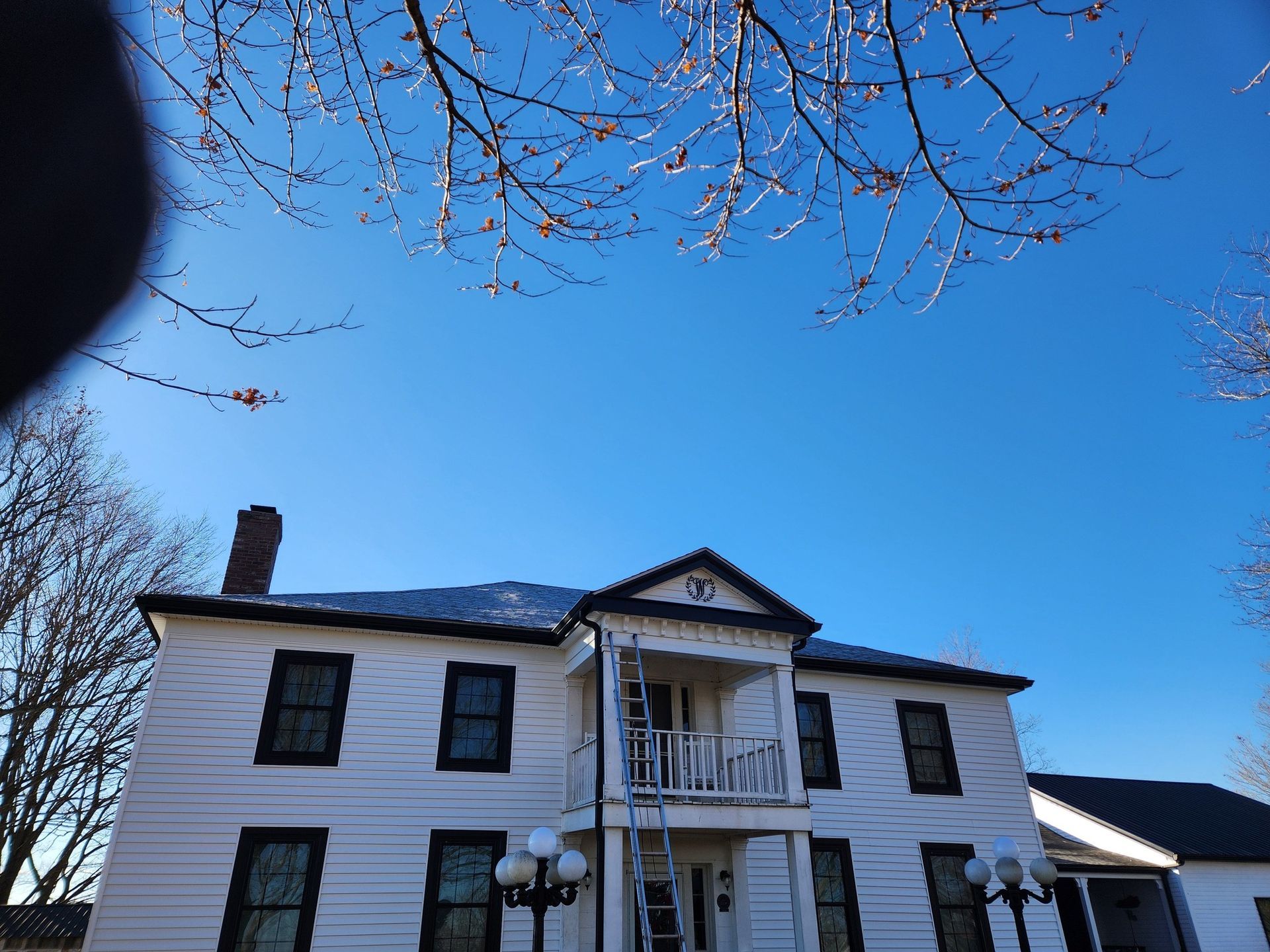 A white house with two lights on the side of it.