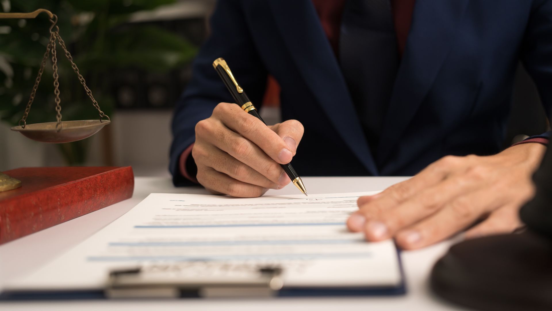 A man is writing on a clipboard with a pen.