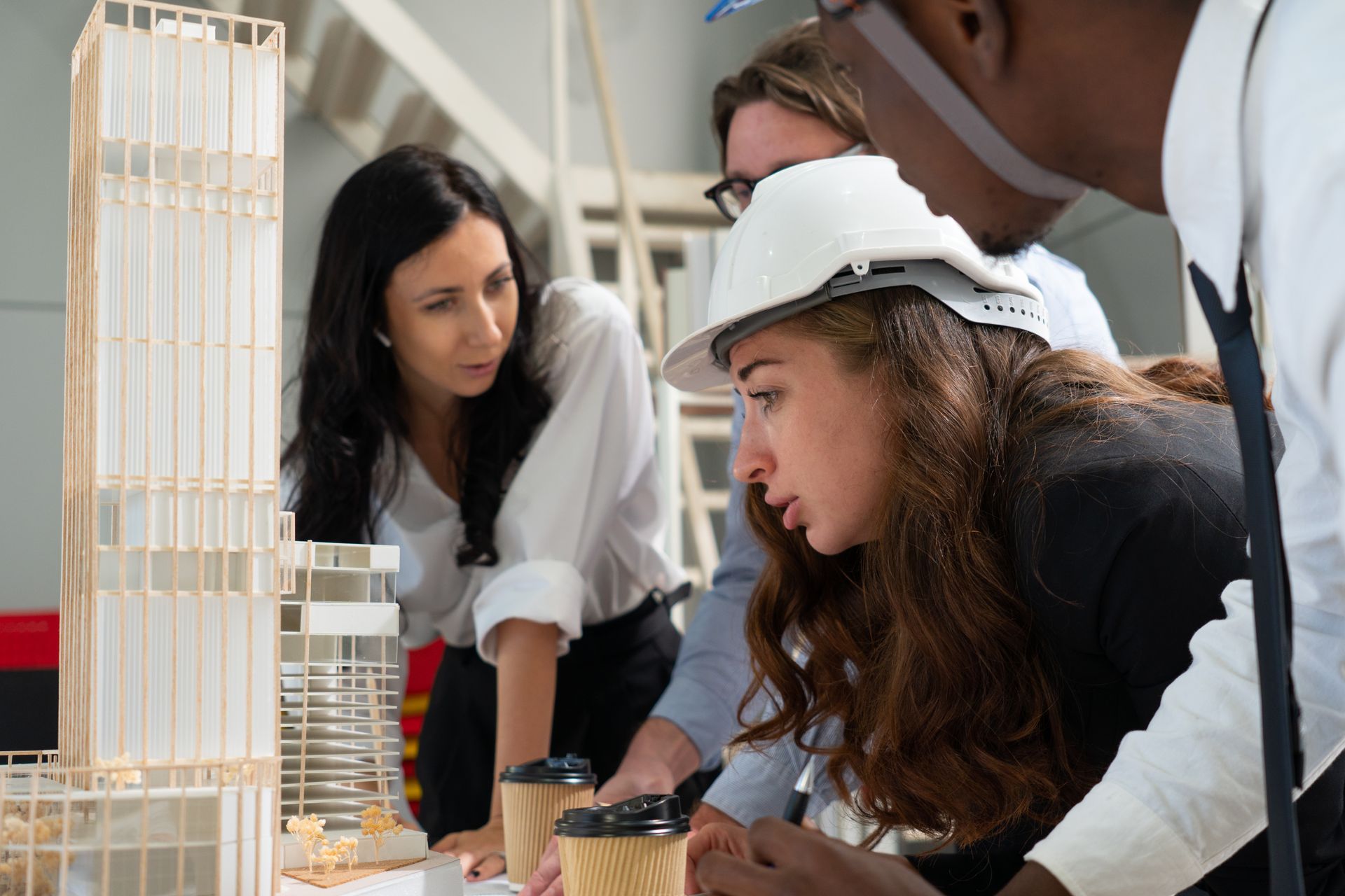 Un grupo de personas está mirando una maqueta de un edificio.