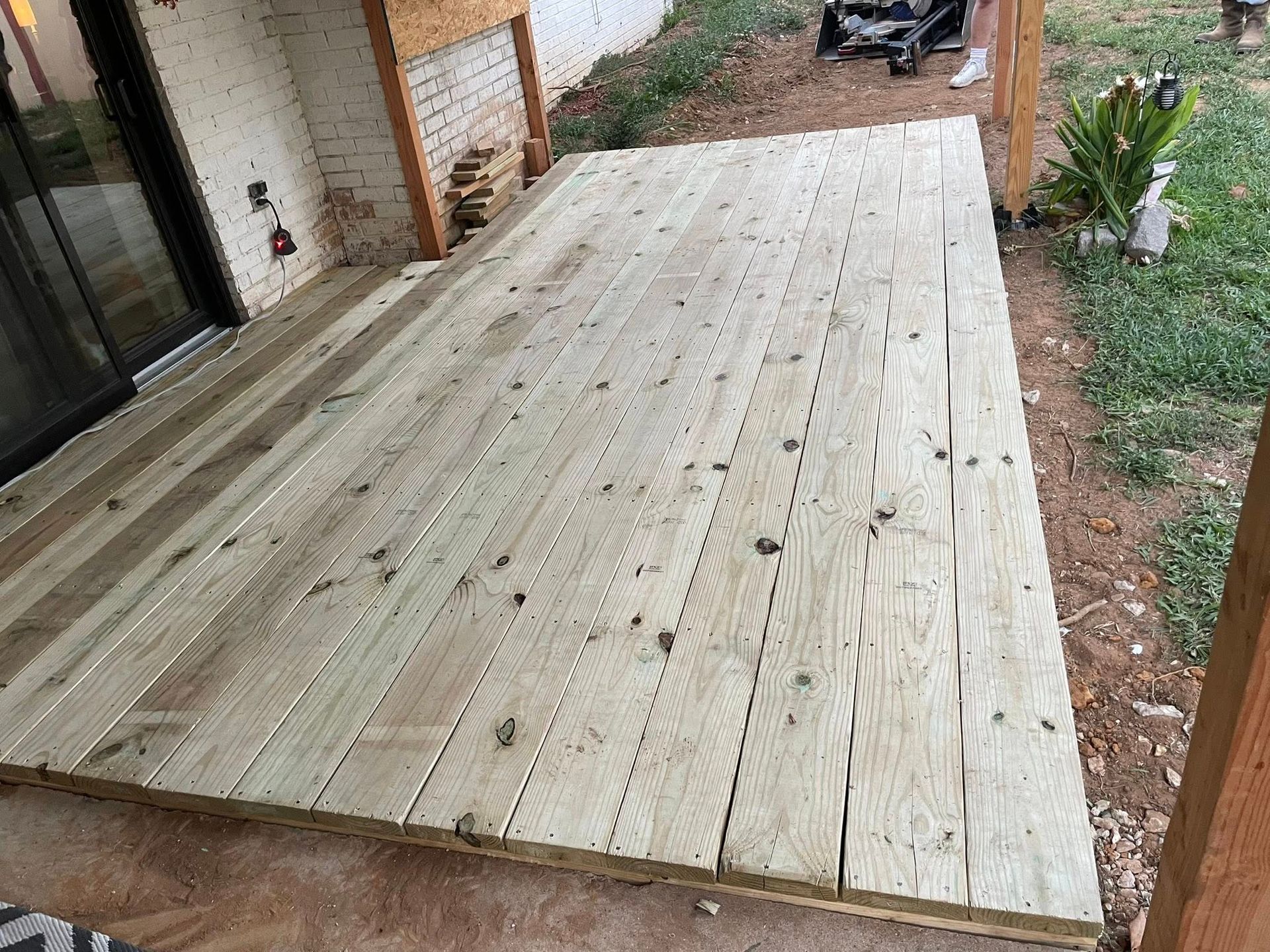 Wooden deck extension, newly built, next to a building.