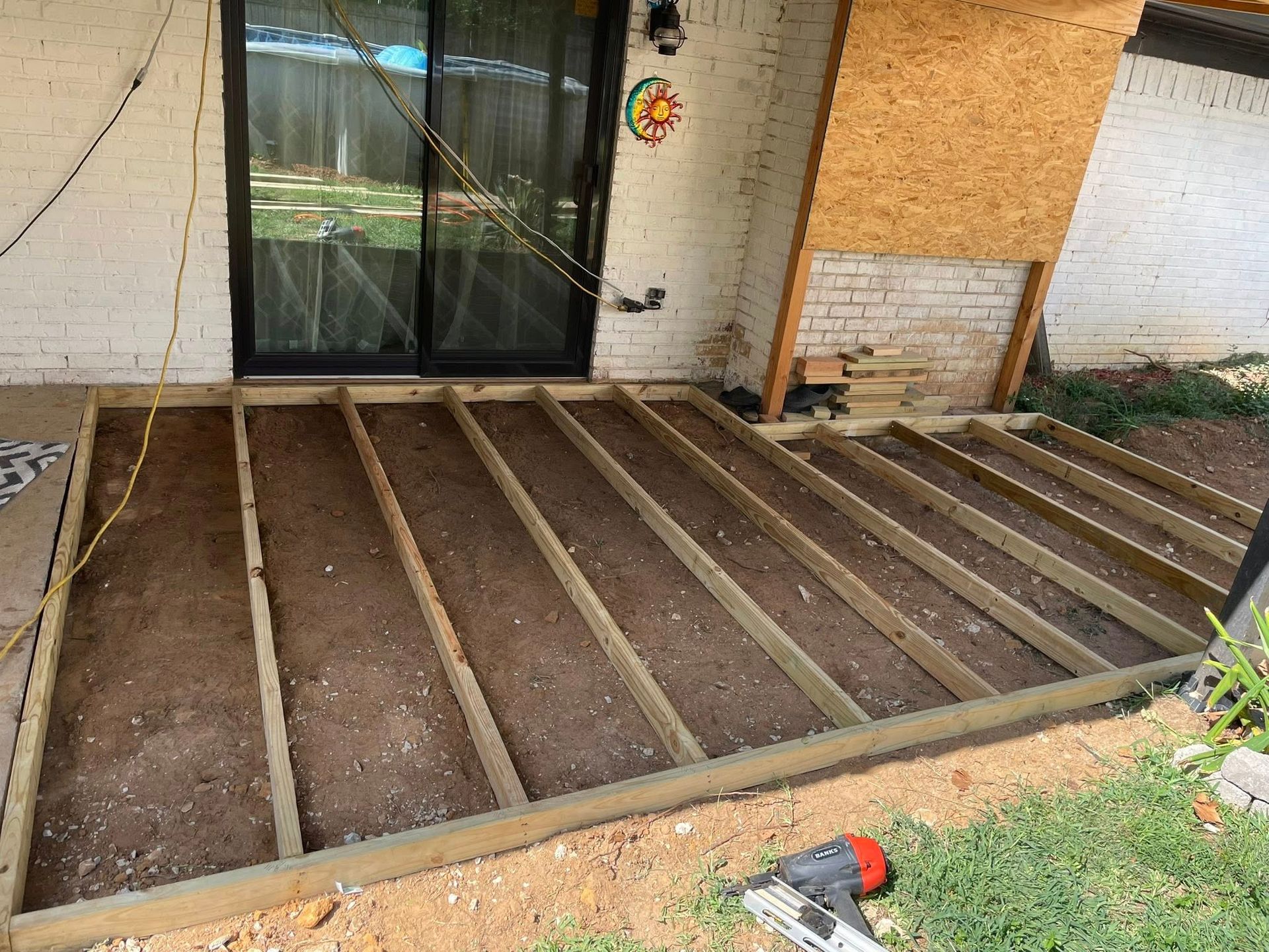 Deck frame construction in progress on a concrete patio.