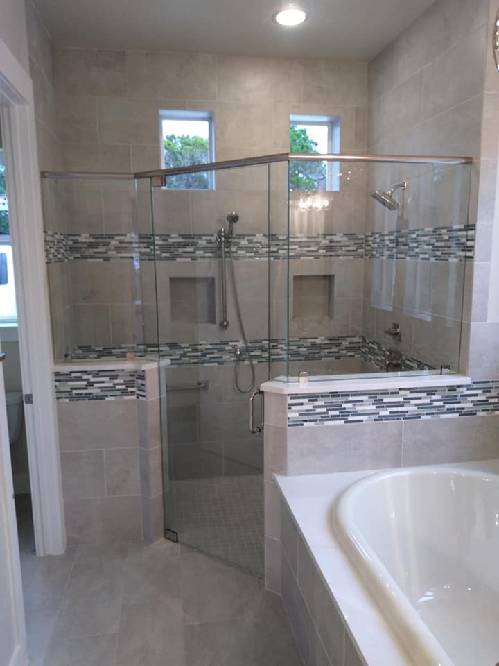 A bathroom with a walk in shower and a bathtub.