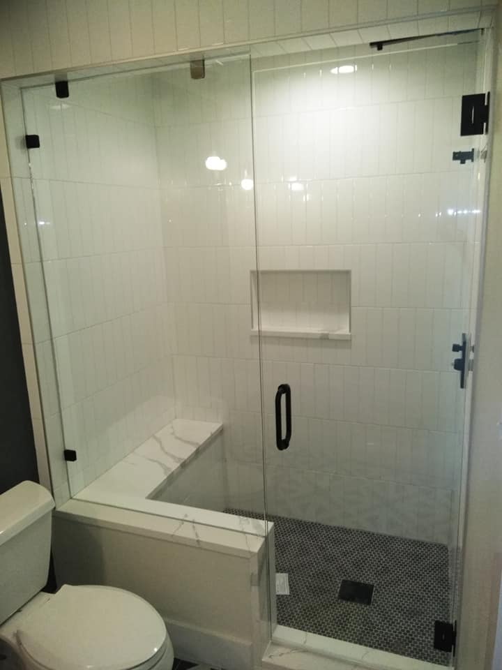 A bathroom with a toilet and a glass shower door.