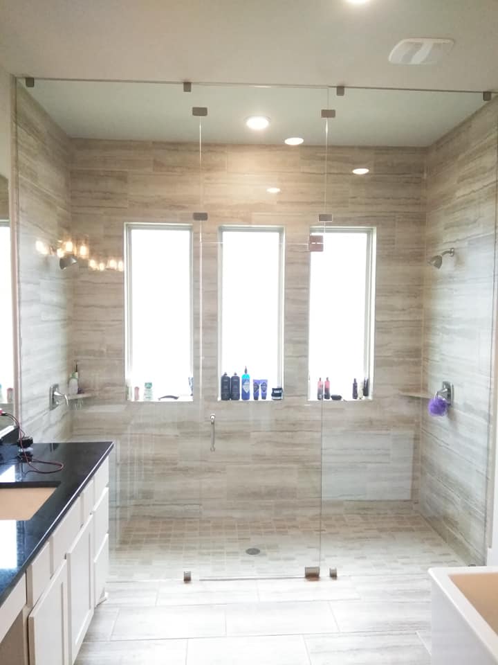 A bathroom with a walk in shower and a sink.