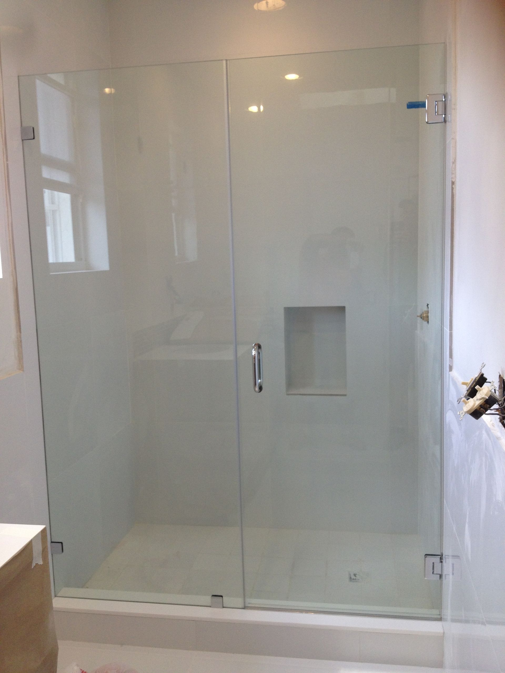 A bathroom with a glass shower door and a sink.