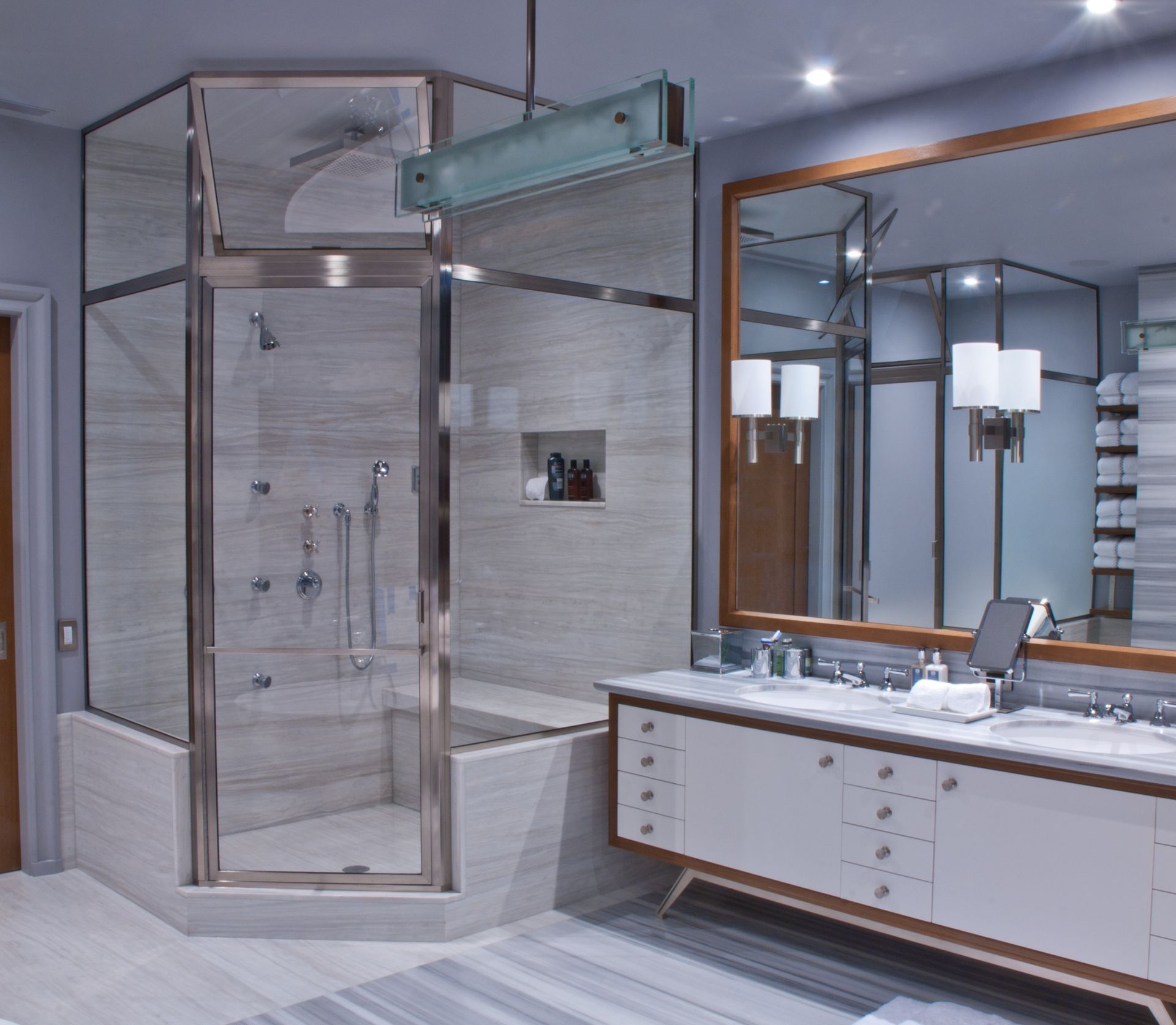 A bathroom with a walk in shower and a large mirror