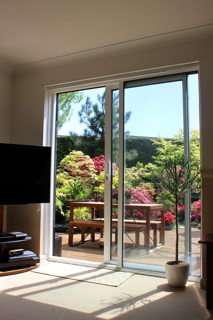 A living room with a sliding glass door leading to a garden