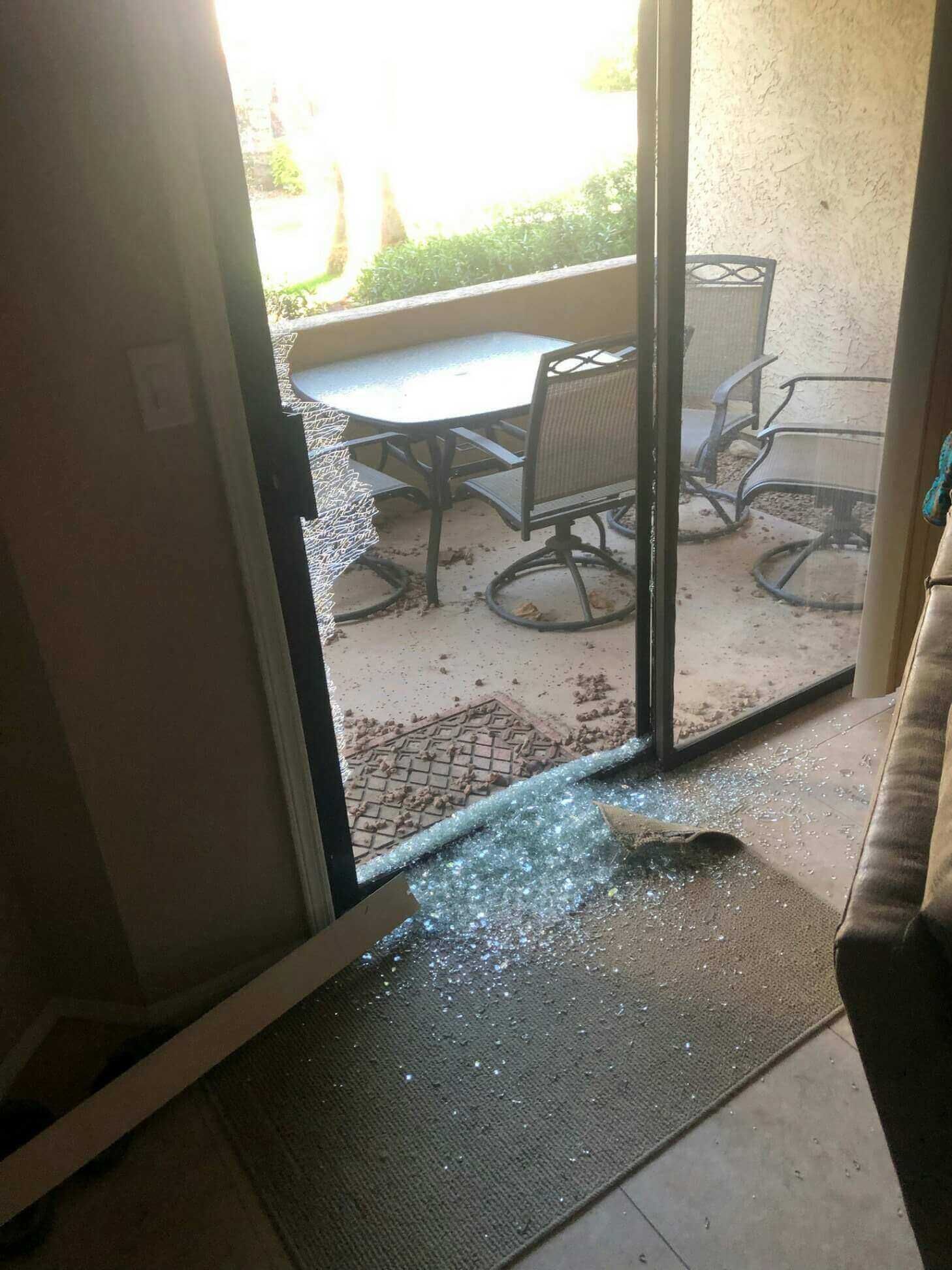 A sliding glass door with a table and chairs behind it.
