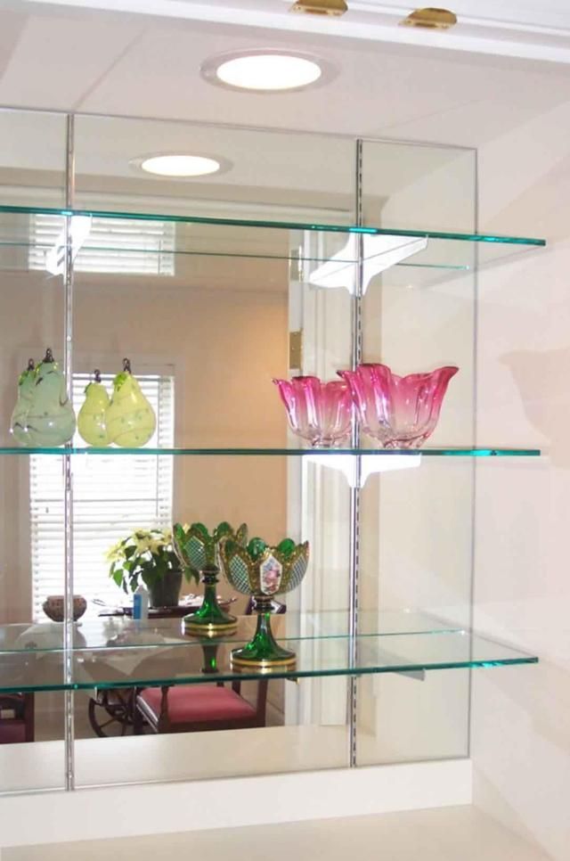 A glass shelf with a mirror behind it