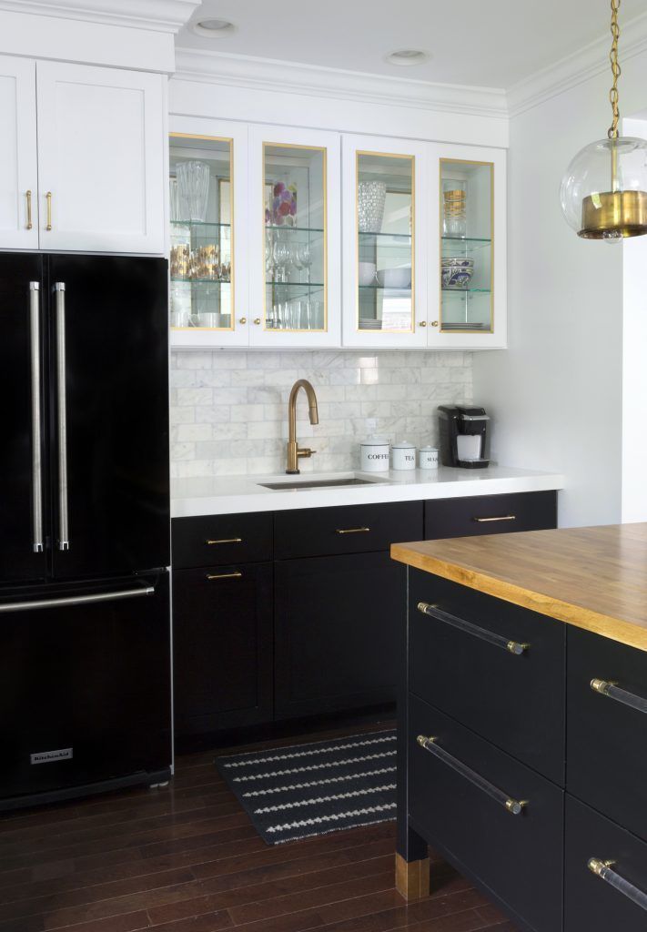 A kitchen with black cabinets and a black refrigerator