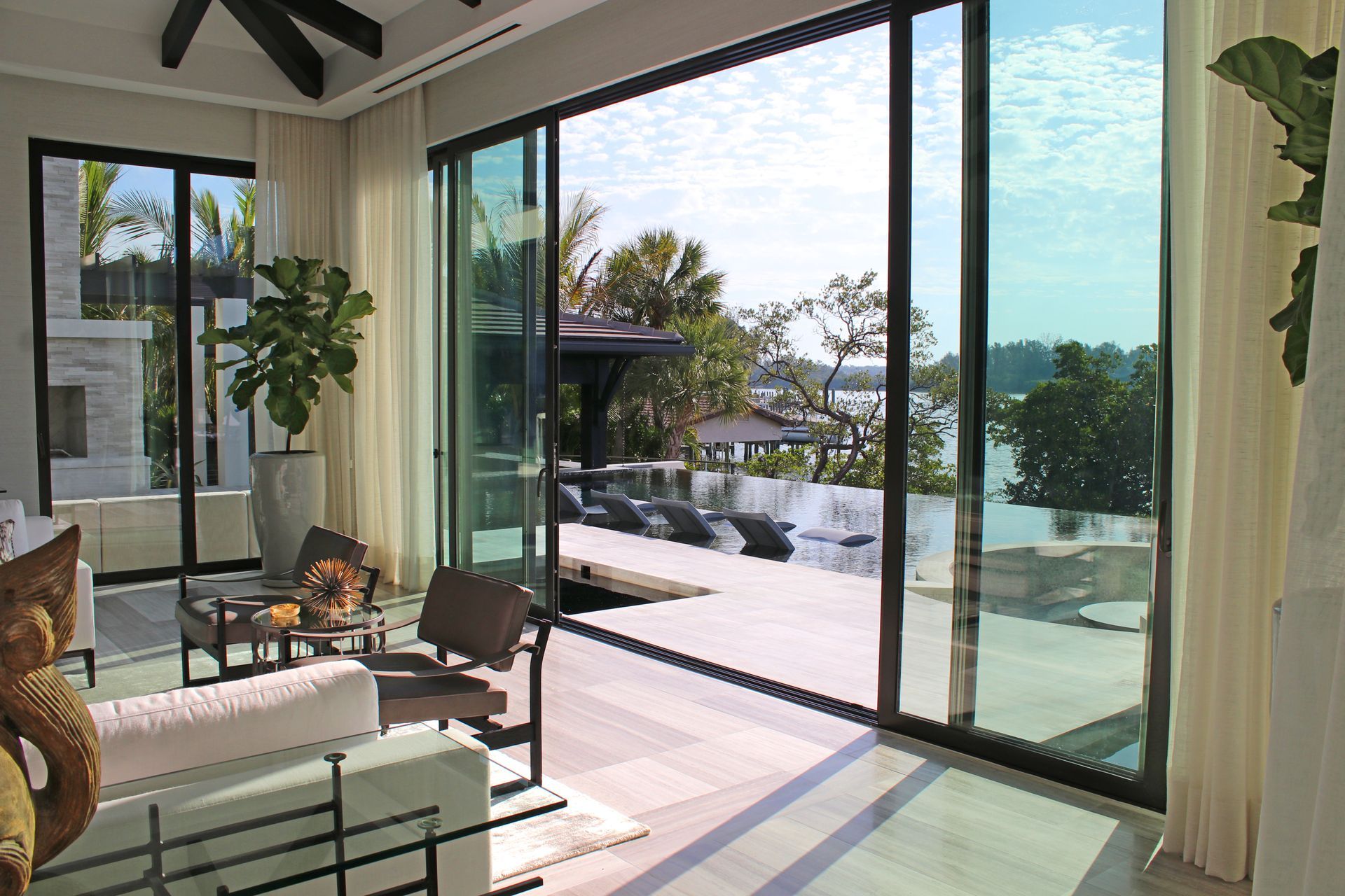 A living room with sliding glass doors leading to a swimming pool.