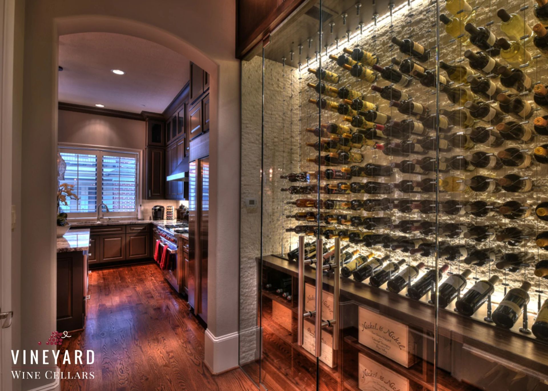 A wine cellar filled with lots of wine bottles in a kitchen.