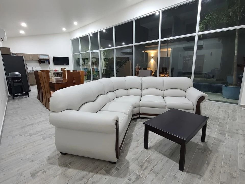 A living room with a white sectional couch and a coffee table